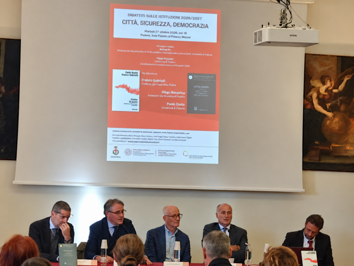 Sicurezza a Padova. Il dibattito “Città, sicurezza, democrazia” a Padova, con i relatori seduti al tavolo davanti alla proiezione dell'evento.