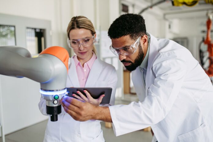 Startup innovative a Padova, ricercatori al lavoro con un braccio robotico in laboratorio.