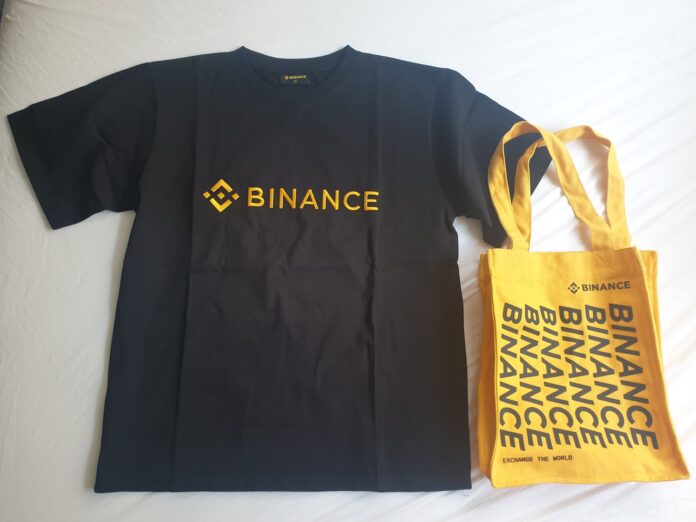 Attacco a Binance, il marchio della piattaforma su una maglietta e una borsa in una foto d’archivio