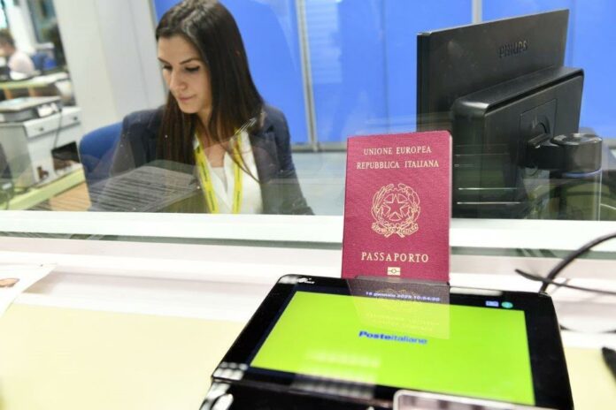 Passaporti alle Poste: documento e postazione digitale davanti a uno sportello postale