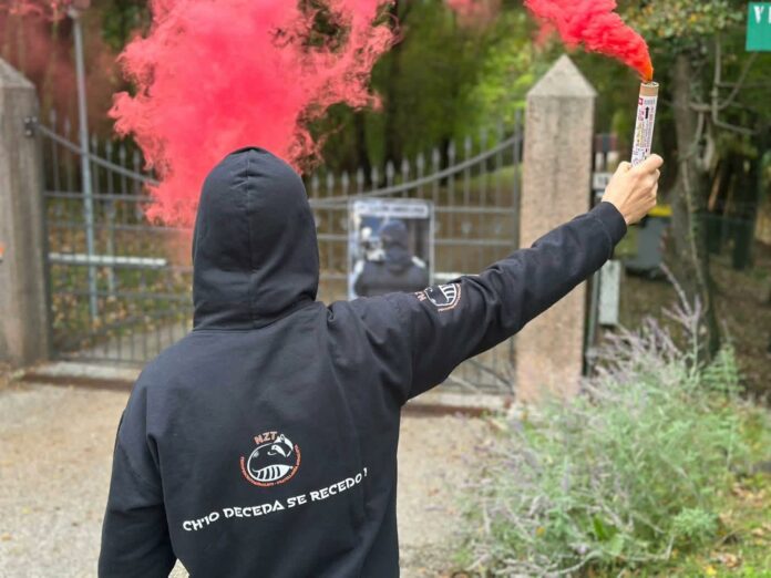 Protesta per l’orso Papillon: attivista con fumogeno rosso davanti al Casteller