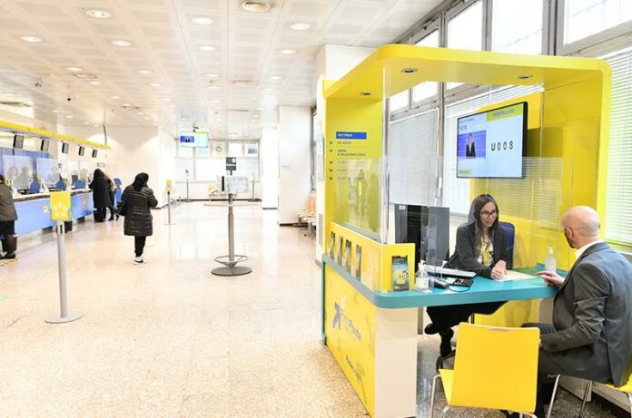 Consulenti Poste: sportelli e clienti all’interno di un ufficio postale